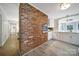 Modern kitchen with white cabinets, an exposed brick wall, and stainless steel appliances, creating a cozy atmosphere at 3800 Lovett Cir, Charlotte, NC 28210