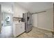 Kitchen area featuring stainless steel refrigerator, white cabinets, and sliding barn door at 3800 Lovett Cir, Charlotte, NC 28210