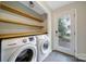 Bright laundry room with shelving, a new washer and dryer, and a glass door leading to the outside at 3800 Lovett Cir, Charlotte, NC 28210
