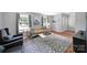 Cozy living room featuring a modern sofa, patterned rug, and ample natural light at 3800 Lovett Cir, Charlotte, NC 28210
