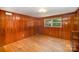 Cozy bedroom with wood paneled walls, hardwood floors, and a bright window at 409 Edgewood Ct, Lancaster, SC 29720