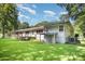 Exterior shot of the home's rear, showing a sprawling backyard, deck and covered patio at 409 Edgewood Ct, Lancaster, SC 29720