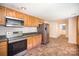 Traditional eat-in kitchen featuring wood cabinets, stainless steel appliances, and updated flooring at 409 Edgewood Ct, Lancaster, SC 29720