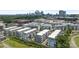 Drone shot of a housing community with new construction, green space and a city skyline in the background at 5006 Tiny Ln, Charlotte, NC 28203