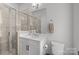 Well-lit bathroom featuring a glass-enclosed shower and a white vanity with a sleek countertop at 5006 Tiny Ln, Charlotte, NC 28203