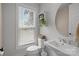Bright bathroom showcasing white sink, toilet, and window with blinds at 5006 Tiny Ln, Charlotte, NC 28203