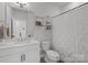Neat bathroom featuring a shower, storage shelving and a white vanity with a sleek countertop at 5006 Tiny Ln, Charlotte, NC 28203