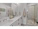 Bright bathroom featuring double sinks, a large mirror, and a glass-enclosed shower at 5006 Tiny Ln, Charlotte, NC 28203