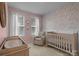 Charming Bedroom with pink walls, floral wallpaper, and a crib at 5006 Tiny Ln, Charlotte, NC 28203