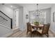 Dining area with wood table, modern chandelier, and view of stairs with black metal railing at 5006 Tiny Ln, Charlotte, NC 28203