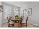 Bright dining area features modern chandelier, wood table, and large windows at 5006 Tiny Ln, Charlotte, NC 28203