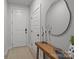Bright entryway featuring a round mirror, a sleek wooden console table, and neutral-toned walls at 5006 Tiny Ln, Charlotte, NC 28203