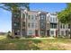 Charming townhome exteriors with brick and siding accents, complemented by lush landscaping and blue sky at 5006 Tiny Ln, Charlotte, NC 28203
