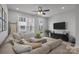 Inviting living room with sectional sofa, modern ceiling fan, and plenty of natural light at 5006 Tiny Ln, Charlotte, NC 28203