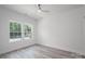 Bright bedroom with luxury vinyl flooring, neutral paint, ceiling fan, and two windows at 520 E Main St, Dallas, NC 28034