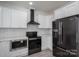 Updated kitchen featuring a black appliance suite, bright white cabinets, and new lighting at 520 E Main St, Dallas, NC 28034