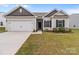 Traditional home exterior with a two-car garage, tidy lawn, and minimal landscaping at 5314 Upton Pl, Charlotte, NC 28215