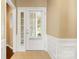 Bright entryway featuring a white door, transom window, and neutral walls with classic wainscoting at 56119 Finches Ct, Indian Land, SC 29707
