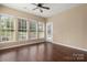 Living room with hardwood floors, three windows, and a ceiling fan at 56119 Finches Ct, Indian Land, SC 29707