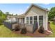 A back exterior view showcasing a fenced deck with a retractable awning and lush, private landscaping at 56119 Finches Ct, Indian Land, SC 29707