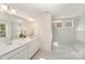 Modern bathroom featuring double sinks with quartz countertops and a glass enclosed shower with tile surround at 635 R L Stowe Rd, Belmont, NC 28012