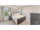 Cozy bedroom featuring natural light from the two windows, soft carpeting, and neutral gray walls at 635 R L Stowe Rd, Belmont, NC 28012