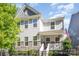 Charming two-story home featuring stone accents, a welcoming front porch, a fenced yard, and a US flag at 635 R L Stowe Rd, Belmont, NC 28012
