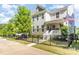 Well-maintained home showcasing a black metal fence, mature tree, a small lawn, and landscaped garden beds at 635 R L Stowe Rd, Belmont, NC 28012
