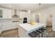 Modern kitchen features white cabinets, stainless steel appliances, and an island with seating at 635 R L Stowe Rd, Belmont, NC 28012