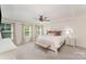 Bright main bedroom featuring a tray ceiling, ceiling fan, neutral palette and a decorative bench at 635 R L Stowe Rd, Belmont, NC 28012