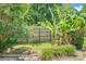 A green backyard with a garden and a wooden fence under a partly cloudy sky at 7912 Charter Oak Ln, Charlotte, NC 28226