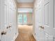 A hallway is shown with white doors and tan carpet at 7912 Charter Oak Ln, Charlotte, NC 28226