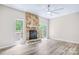 Bright living room with a striking stone fireplace and access to outdoor spaces at 7912 Charter Oak Ln, Charlotte, NC 28226
