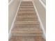 A staircase is shown with beige carpeting and white trim at 7912 Charter Oak Ln, Charlotte, NC 28226