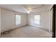 Clean bedroom featuring carpet, neutral walls, and natural light from two windows at 8112 Blackwood Rd, Denver, NC 28037