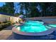 Backyard at night featuring an in-ground pool with lights, a gazebo covered seating area, and a manicured lawn at 932 Shady Bluff Dr, Charlotte, NC 28211