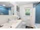 Well-lit bathroom with blue tile shower, marble vanity, and decorative touches at 932 Shady Bluff Dr, Charlotte, NC 28211