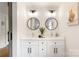 Bathroom featuring a double vanity, modern lighting, round mirrors, and neutral decor at 932 Shady Bluff Dr, Charlotte, NC 28211