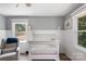 Charming Bedroom featuring wainscoting, a chair, and a view of the outdoors through two windows at 932 Shady Bluff Dr, Charlotte, NC 28211
