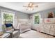 Cozy Bedroom with white wainscoting, chair and crib, and two windows for natural light at 932 Shady Bluff Dr, Charlotte, NC 28211