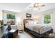 Bright bedroom with ceiling fan, comfortable bed, and natural light from dual windows at 932 Shady Bluff Dr, Charlotte, NC 28211