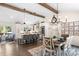 Open kitchen and dining room showcasing wood beams, lighting, and stainless steel appliances at 932 Shady Bluff Dr, Charlotte, NC 28211