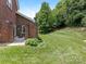 Well-maintained backyard with lush green grass and a brick wall bordering the patio at 9451 Bonnie Briar Cir, Charlotte, NC 28277