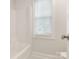 Bright, simple bathroom with a tub and a window letting in natural light at 9451 Bonnie Briar Cir, Charlotte, NC 28277