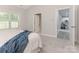 Bright bedroom featuring a window, carpet, and open doorway to another room at 9451 Bonnie Briar Cir, Charlotte, NC 28277