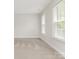 Neutral bedroom with light carpeting and two windows letting in light at 9451 Bonnie Briar Cir, Charlotte, NC 28277