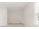 Bright bedroom with a window, light gray carpet, and a white interior door at 9451 Bonnie Briar Cir, Charlotte, NC 28277