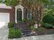 Charming brick home showcasing a stylish front door, black shutters, and lush landscaping at 9451 Bonnie Briar Cir, Charlotte, NC 28277