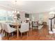Sunlit living room with hardwood floors, fireplace, and elegant dining area at 9451 Bonnie Briar Cir, Charlotte, NC 28277