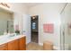 Bright bathroom featuring a vanity with a mirror, a shower, and an open doorway leading to a bedroom at 1006 Apogee Dr, Indian Trail, NC 28079